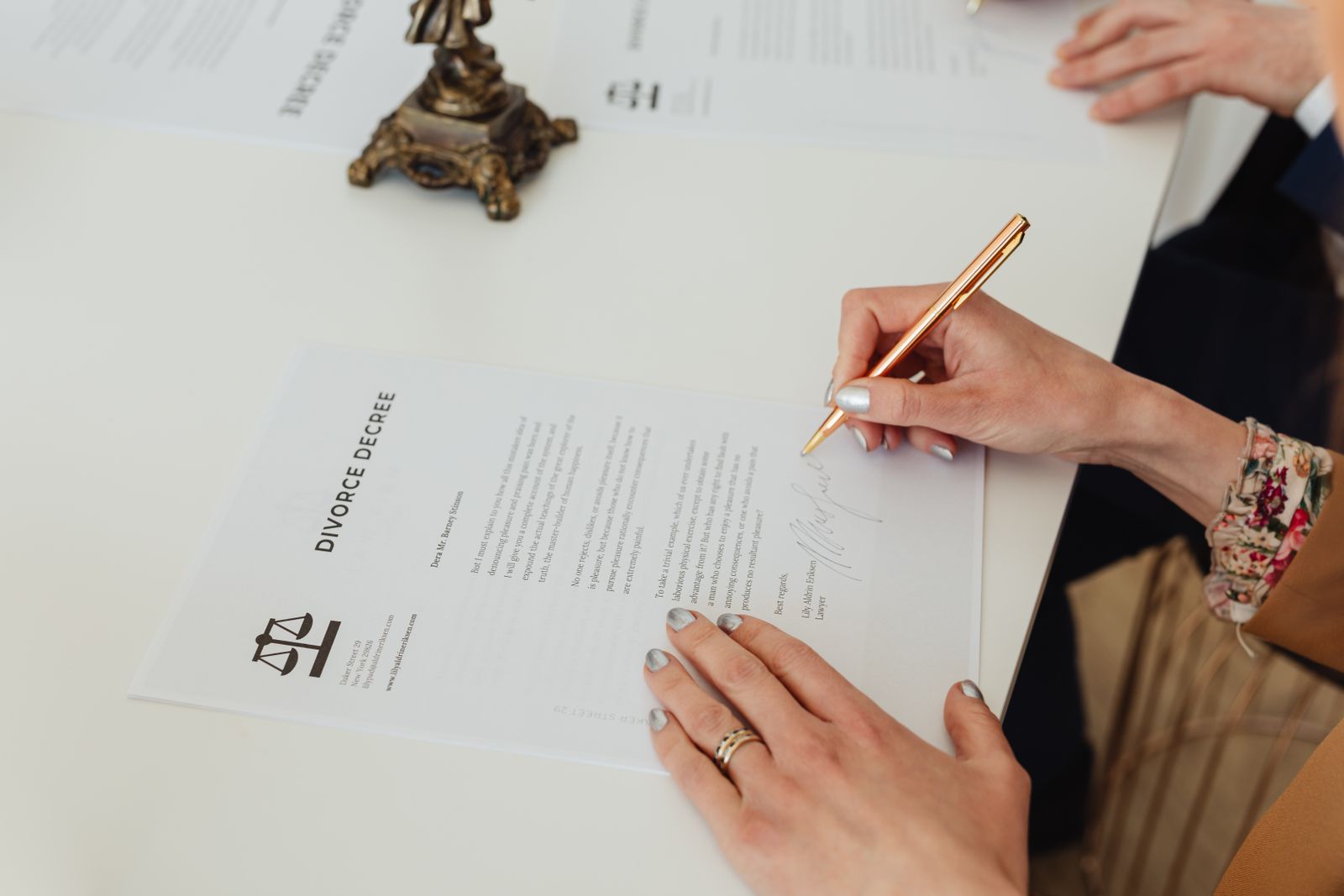 A document being signed and witnessed across a desk