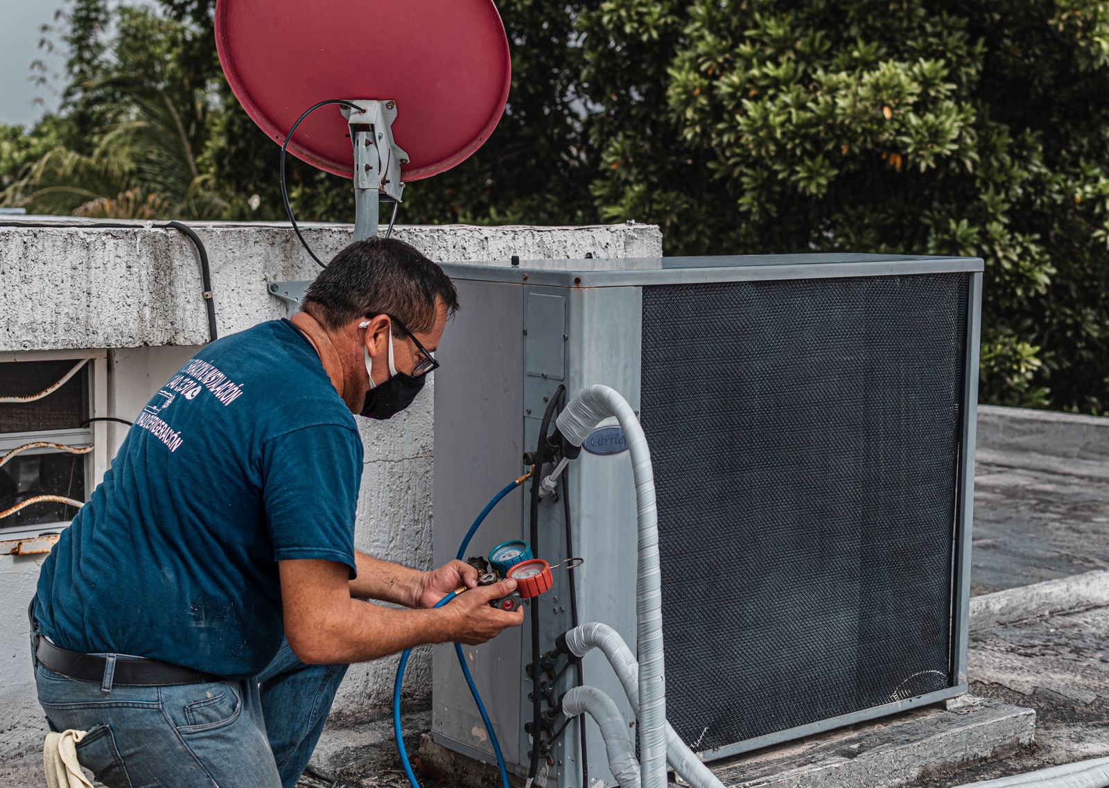 A technician working on an outdoor air-conditioning unit