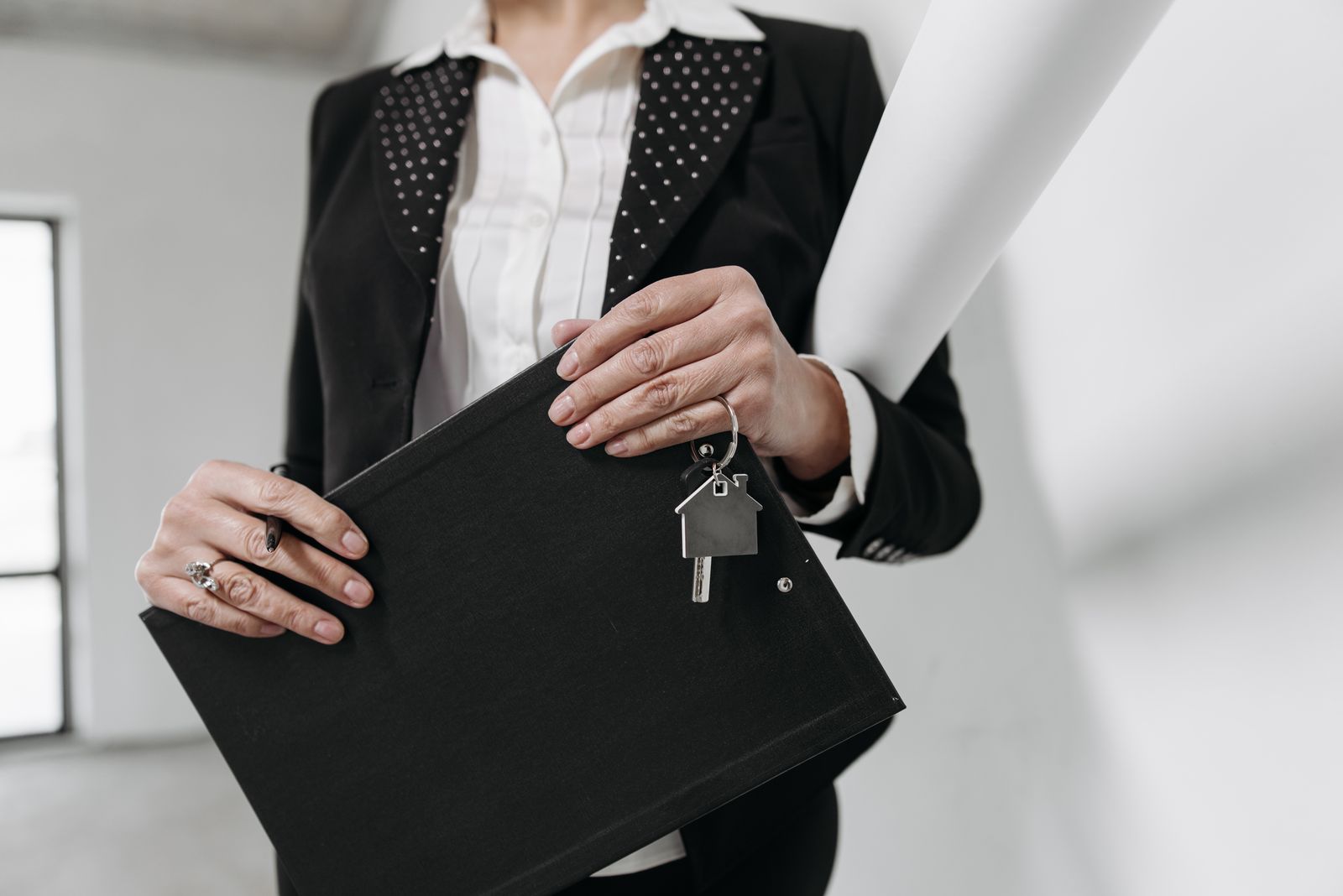An agent holding keys and a clipboard in an office